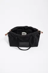 Bolso de hombro Bimba y Lola de tamaño grande, confeccionado en nylon negro con estructura blanda. Presenta dos asas largas, cierre superior y detalles de cordones laterales en tonos tierra. Incluye un parche frontal con el logo de la marca grabado.