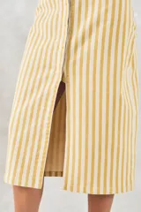 Falda midi de denim a rayas verticales amarillas y blancas, con abertura frontal y cierre con botones.