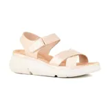 Sandalia casual color beige con plataforma blanca, tiras anchas cruzadas en el empeine y ajuste con velcro en el tobillo.