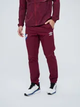 Pantalón de entrenamiento Umbro del Club Nacional de Football, modelo Grok en color azul. Presenta el escudo del club en una pierna y el logo de Umbro en la otra, con diseño cómodo y deportivo.