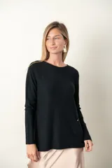 Buzo color verde azulado de tejido de punto fino con frente acanalado y bolsillo con botón de strass.