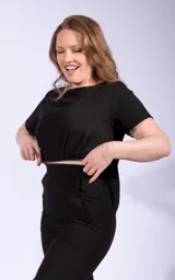 Mono negro de dos piezas, compuesto por una remera de mangas cortas y un pantalón capri de tiro alto.