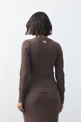 Sweater de tejido tipo rib, color negro, con cuello redondo y mangas largas. Presenta una textura acanalada y un ajuste al cuerpo.
