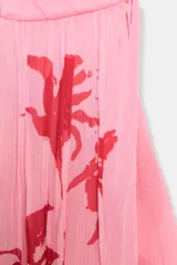 Top sin mangas color rosa con estampado de flores rojas, cuello halter y espalda descubierta.