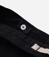 Pantalón skinny de sarga color negro, con cintura con trabillas, elástico regulador interno, cierre por cremallera y botón, y bolsillos.