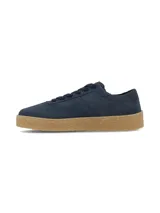 Championes de gamuza azul marino, con cordones al tono y suela texturizada de goma en color tostado.