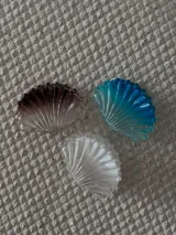 Broche con forma de concha marina en color azul, blanco y marrón.