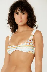 Conjunto de bikini estampado con motivos de soles, palmeras y figuras geométricas en tonos naranja, celeste y blanco. El corpiño es de corte recto con breteles anchos y detalle de nudo en el centro. La bombacha es de corte clásico.