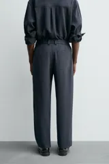 Pantalón de corte relaxed fit, con cintura ajustable, bolsillos delanteros y bolsillo trasero de plastrón. Presenta cierre frontal con cremallera y botón.