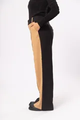 Pantalón fluido de tiro alto con bolsillos delanteros y traseros. Cierre frontal con cremallera y botón. Diseño color block negro y beige.
