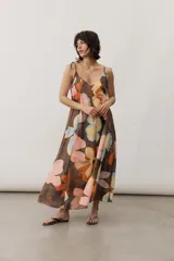 Vestido midi de tirantes ajustables con lazo en los hombros, escote en V y diseño amplio con estampado floral abstracto en tonos marrones, rosados, celestes y amarillos.