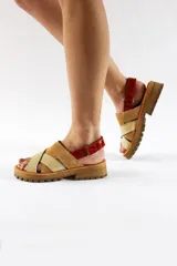 Sandalias con plataforma de cuero color beige y marrón, con tiras cruzadas y ajuste con velcro en el tobillo.