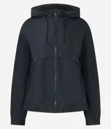 Campera deportiva cortaviento color blanco, con capucha ajustable, cierre frontal por cremallera y diseño de corte holgado. Incluye saquito para guardar.