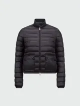 Campera puffer corta Moncler modelo Lans en color negro, con diseño acolchado horizontal, cuello alto y cierre frontal con cremallera doble cursor. Cuenta con bolsillos frontales con solapa y broche a presión.