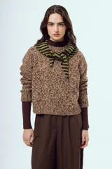 Sweater tejido de punto con acabado moteado en tonos marrones y blancos, de silueta relajada, manga larga y cuello redondo.