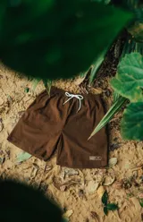 Bermuda marrón de pana con cintura elástica ajustable con cordón blanco.