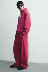 Pantalón jogger relaxed fit color bordó, confeccionado en tejido con algodón e interior forrado en tejido polar. Cuenta con cintura elástica, bolsillos frontales, bolsillos traseros de vivo y detalle de costura frontal en las perneras.
