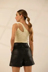 Body color crema de lycra de algodón, con bretel fino y corte asimétrico con abertura en el hombro.