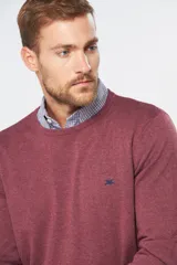 Buzo de punto color verde oscuro, con cuello redondo y mangas largas.