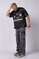 Camiseta de estilo futbolero con cuello polo, manga corta y corte relajado. Presenta un estampado abstracto en tonos grises y negros, con el número 15, el logo de la marca y la palabra Endzone en el frente.