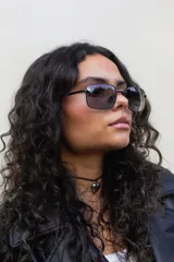 Lentes de sol rectangulares con marco de metal negro y lentes grises.