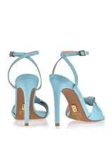 Sandalia de tacón alto color amarillo con pulsera al tobillo y detalle de moño con strass en la capellada.