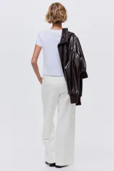 Pantalón de jean blanco de corte wide leg y tiro alto, con diseño de pierna amplia, bolsillos laterales al bies y raya marcada en el frente.