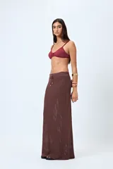 Falda larga tejida color marrón oscuro, con trama calada y cordón ajustable en la cintura.