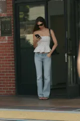 Top palabra de honor de color blanco con estampado de lunares negros, diseño sin tirantes y bajo con volados tipo peplum.