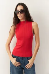 Musculosa negra de tejido de punto acanalado, con cuello alto y corte ajustado.