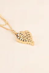 Collar dorado de doble cadena con dije en forma de caracol.