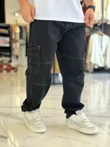 Pantalón cargo de jean azul con múltiples bolsillos en los laterales y diseño holgado.