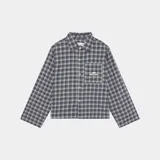 Camisa de franela a cuadros en tonos grises, negros y azules, con cuello clásico, corte ligeramente oversize, cierre frontal con botones y bolsillo en el pecho con logo bordado.