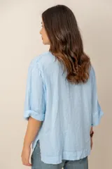 Blusa blanca de lino de manga larga con cuello en V y calce holgado.