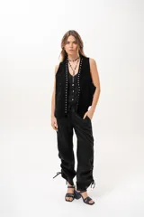 Pantalón negro de tiro medio con cintura elástica ajustable con cordón y detalles de fruncido con tiras en los laterales de las piernas.