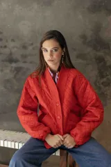 Campera acolchada de color azul marino, con diseño de rombos, cuello tipo chal y cierre frontal con botones grandes al tono. Presenta puños y ruedo acanalados, y bolsillos laterales.