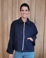 Chaqueta de textura bouclé en color bordó, con corte oversize, cuello camisero, cierre frontal y bolsillos laterales.