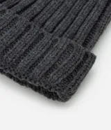 Gorro de punto acanalado color tostado, con diseño clásico de vuelta y pompón de pelo sintético en la parte superior.