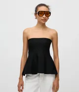 Blusa negra de punto sin breteles, con diseño ajustado en el busto y corte con peplum en el ruedo que aporta volumen y movimiento.