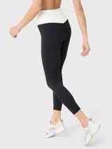 Calza deportiva de tiro alto con diseño bicolor, presentando una cintura en forma de V en color blanco y el resto de la prenda en color negro. Confeccionada en tejido suave y elástico, cuenta con ajuste de silicona en la cintura para mayor sujeción.
