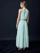 Vestido largo de gasa color verde menta, marca Julia Jordan. Tiene escote halter, cintura elastizada con lazo de ajuste y abertura central en la espalda con botones.