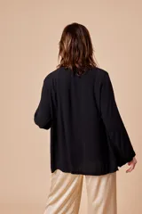 Túnica negra lisa con vivo en satén, modelo abierto y talle único.