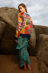 Sweater de lana tejido y bordado a mano con diseño de bloques de colores y motivos florales, de calce holgado, cuello a la base y puños acanalados. Talle único.