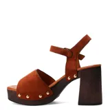 Sandalias de tacón alto Miss Carol modelo Torino, confeccionadas en gamuza marrón. Presentan plataforma con efecto de madera, taco ancho y tira en el empeine con hebilla metálica dorada y tachas decorativas. Incluyen tira ajustable al tobillo con hebilla.