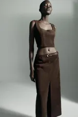 Top crop de escote recto y tirantes anchos, confeccionado en tejido con efecto ante. Presenta un diseño ajustado con cierre lateral mediante cremallera oculta.
