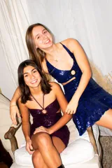 Vestido corto de satén color verde azulado (teal) con escote strapless y detalle de frunce central con argolla. Presenta tirantes finos que se atan al cuello y aberturas laterales en la cintura.