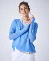 Sweater de punto fino color gris claro, con cuello en V y mangas largas. El tejido parece ser ligeramente transparente o muy liviano.