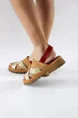 Sandalias con plataforma de cuero color beige y marrón, con tiras cruzadas y ajuste con velcro en el tobillo.