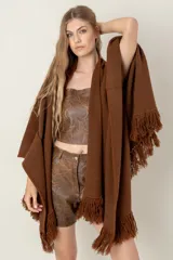 Ruana tejida color bordó, con textura acanalada y flecos largos en los bordes.