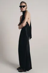 Vestido largo de satén negro con cuello halter subido y espalda descubierta. Presenta un diseño fluido con bajo en línea evasé.